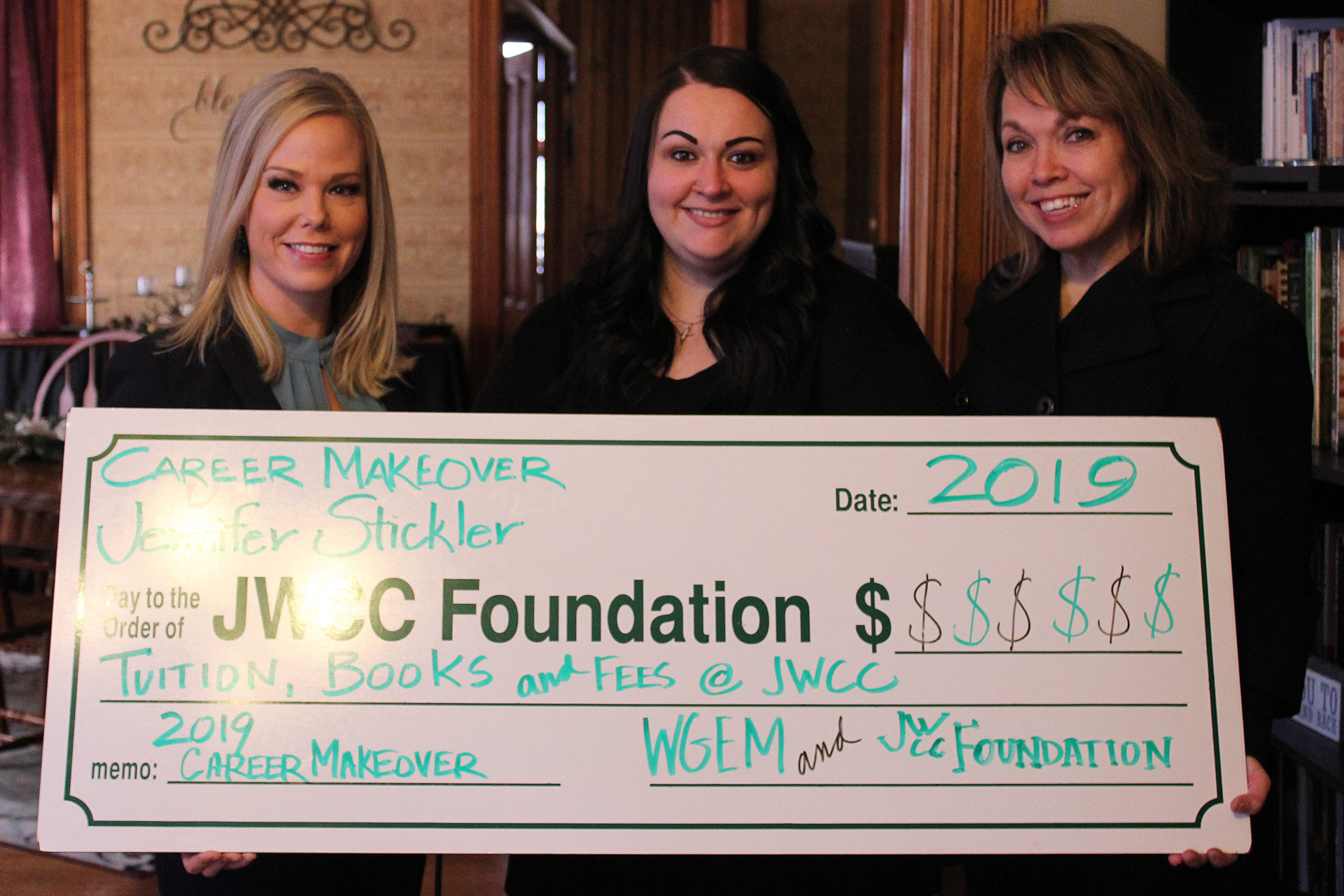 Three woman receive a check from WGEM