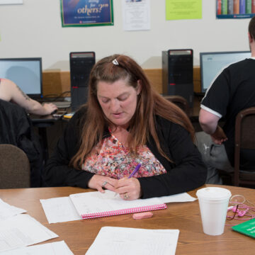 GED Student takes notes on her pink notebook