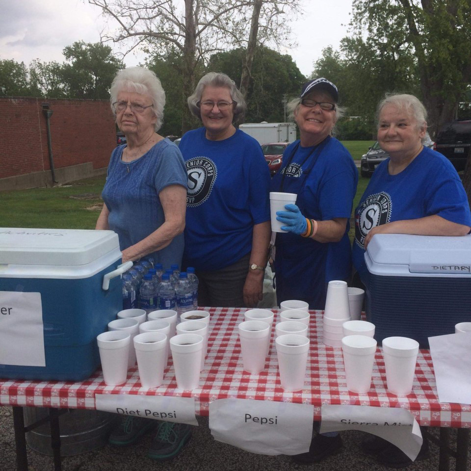 Various ladies serving soda in Styrofoam cups