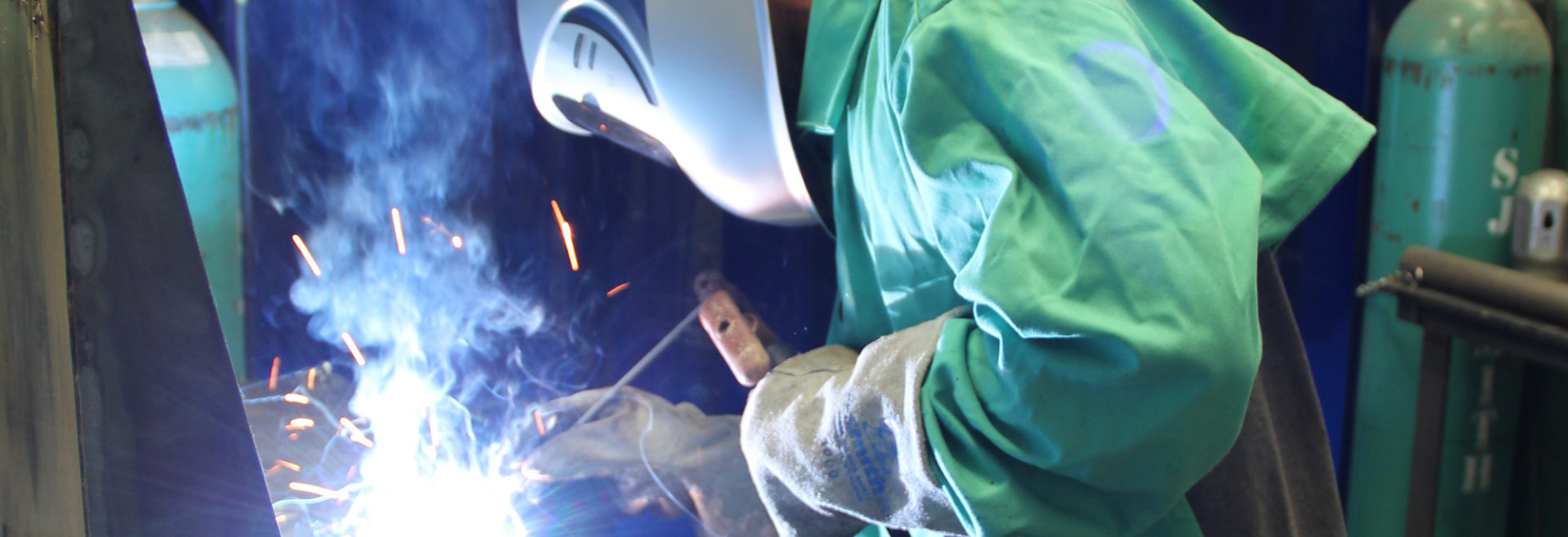 student with protective gear on welding