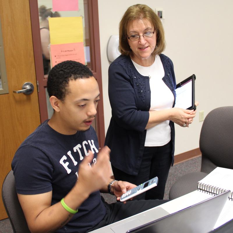 business instructor talking to student at a computer