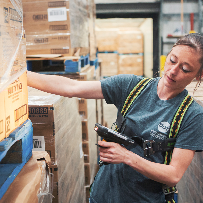 girl using a scanner to scan boxes at a warehouse