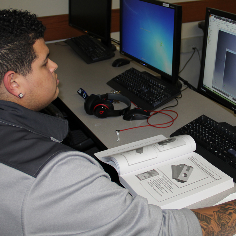 Student working with book and computer