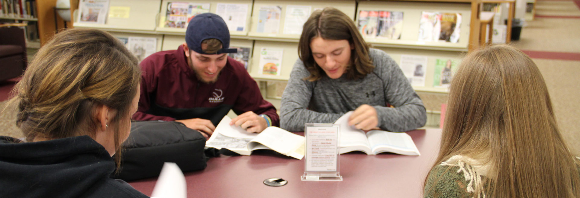 four students at a table in the library
