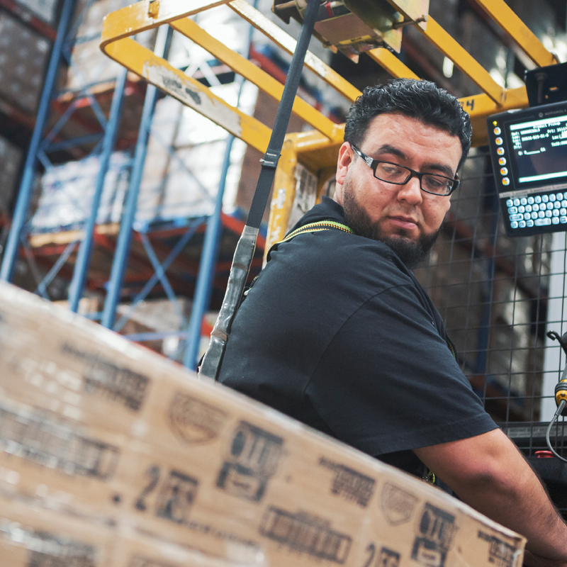 man looking at boxes in a warehouse