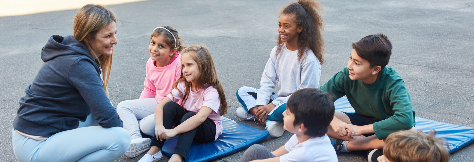 young children sitting on yoga mats listening to the instructor