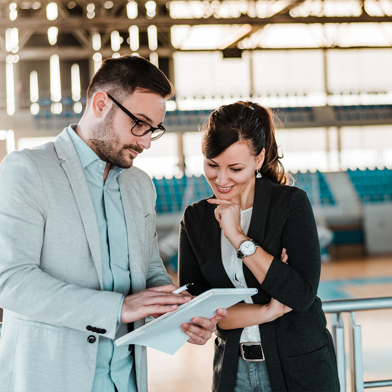 male and female talking looking at a notebook