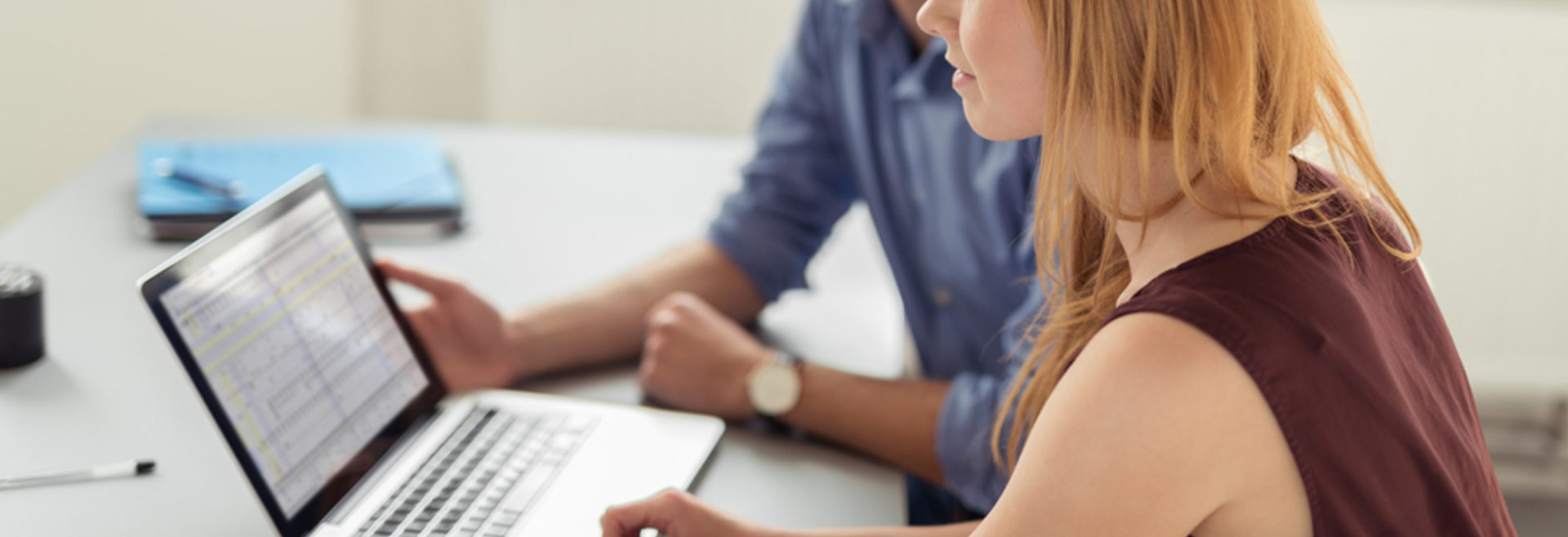 Two people working on a laptop