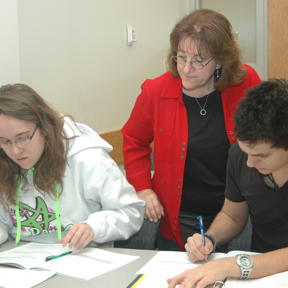 instructor looking over students working