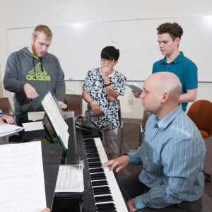 Students practice with instructor Steven Soebbing on the piano