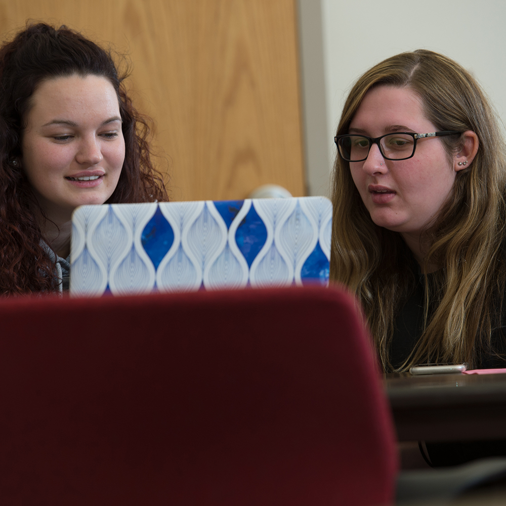 two female students looking at a laptop