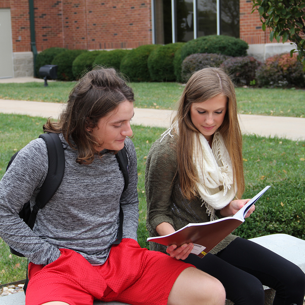 two students looking at a college book