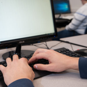 Student typing on a keyboard