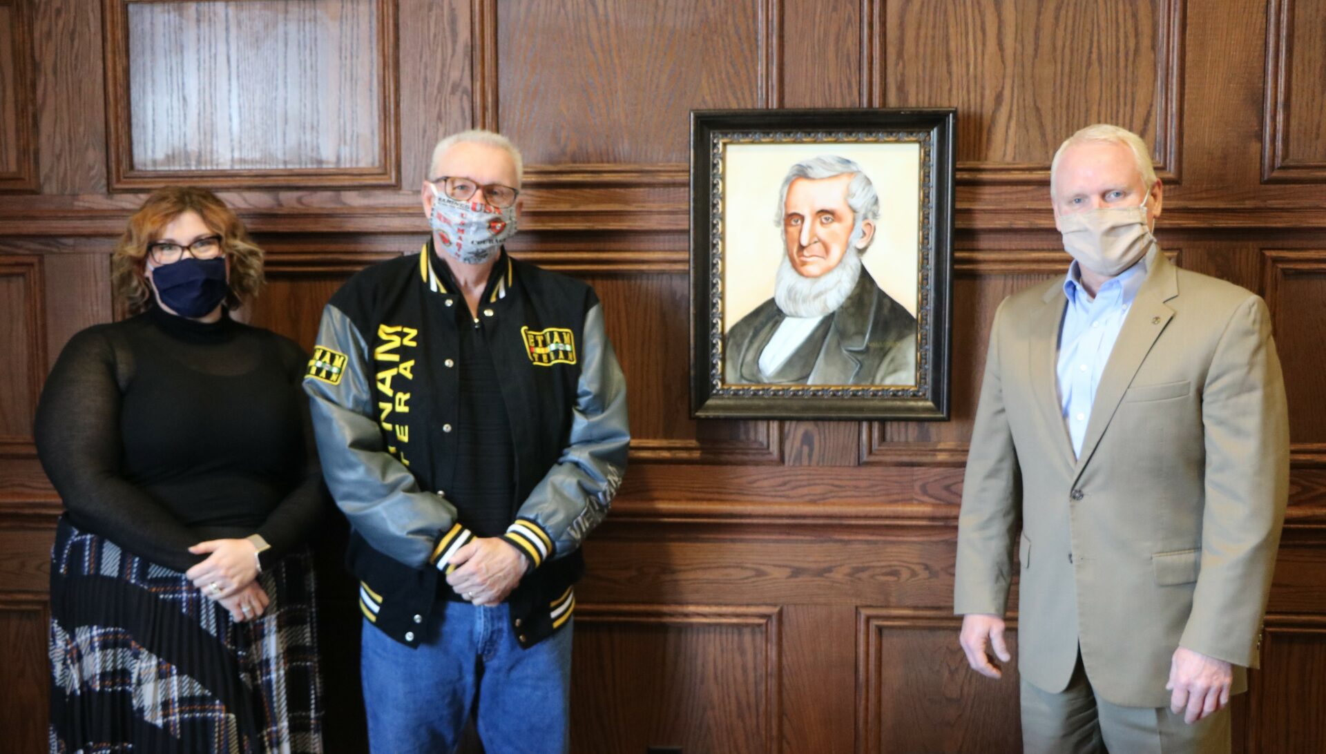 Dan Waggoner poses with his portrait of John Wood. the man