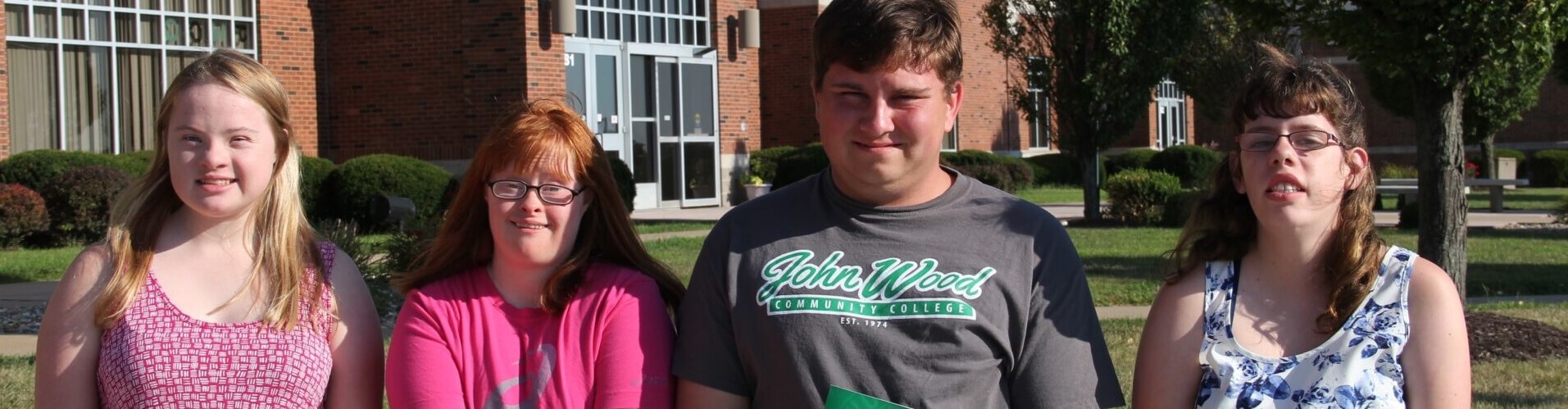 Four College for Life Students pose in front of the John Wood Community College Quincy campus