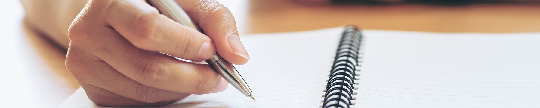 Student writes in spiral-bound notebook