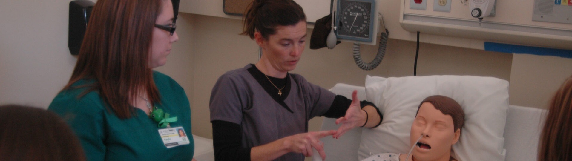 Nursing students discuss medical practices on a dummy