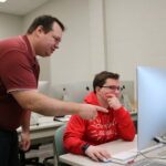 Devron Sternke with a student in the graphic design lab on the Quincy campus.