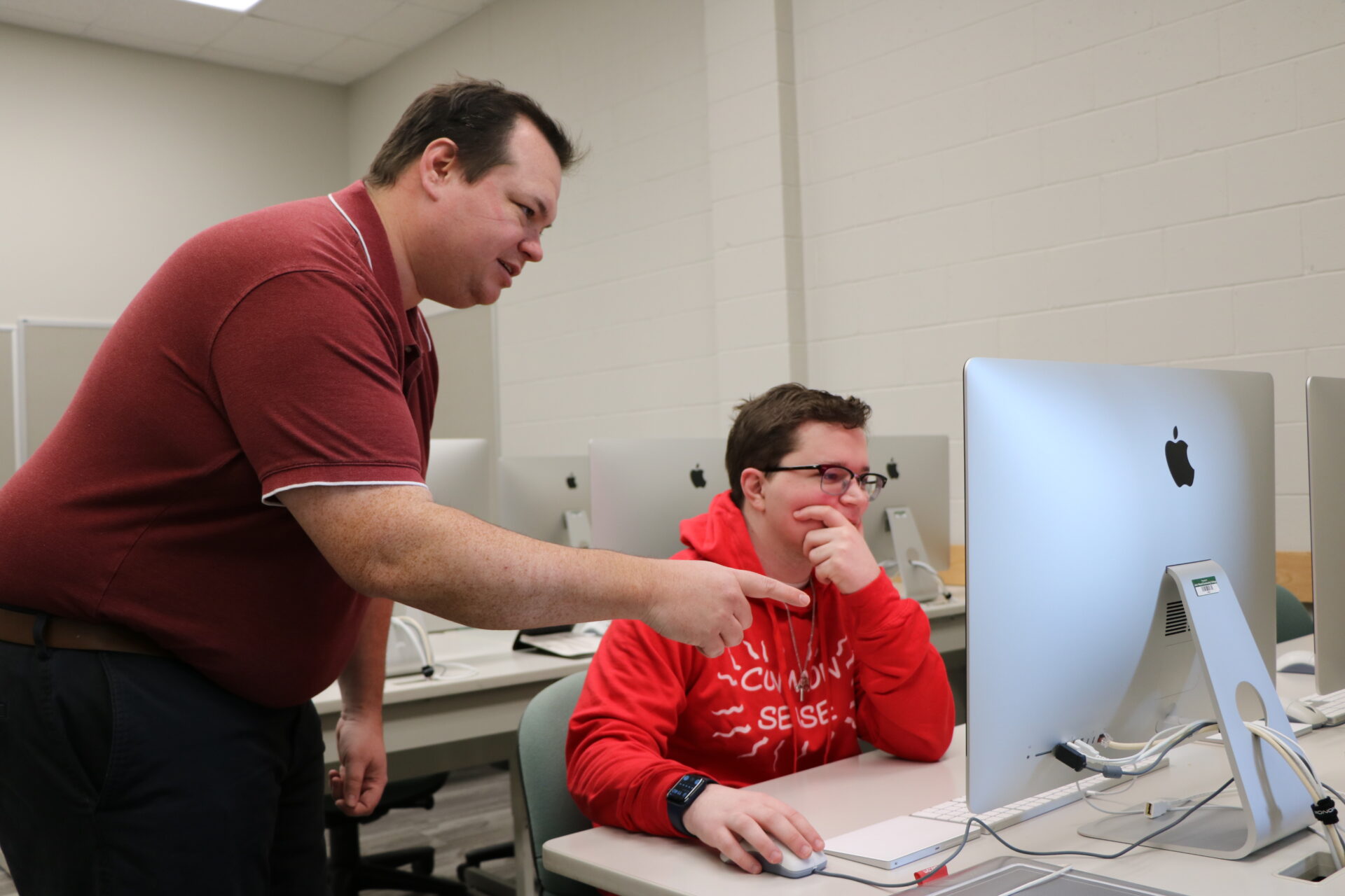 Devron Sternke with a student in the graphic design lab on the Quincy campus.