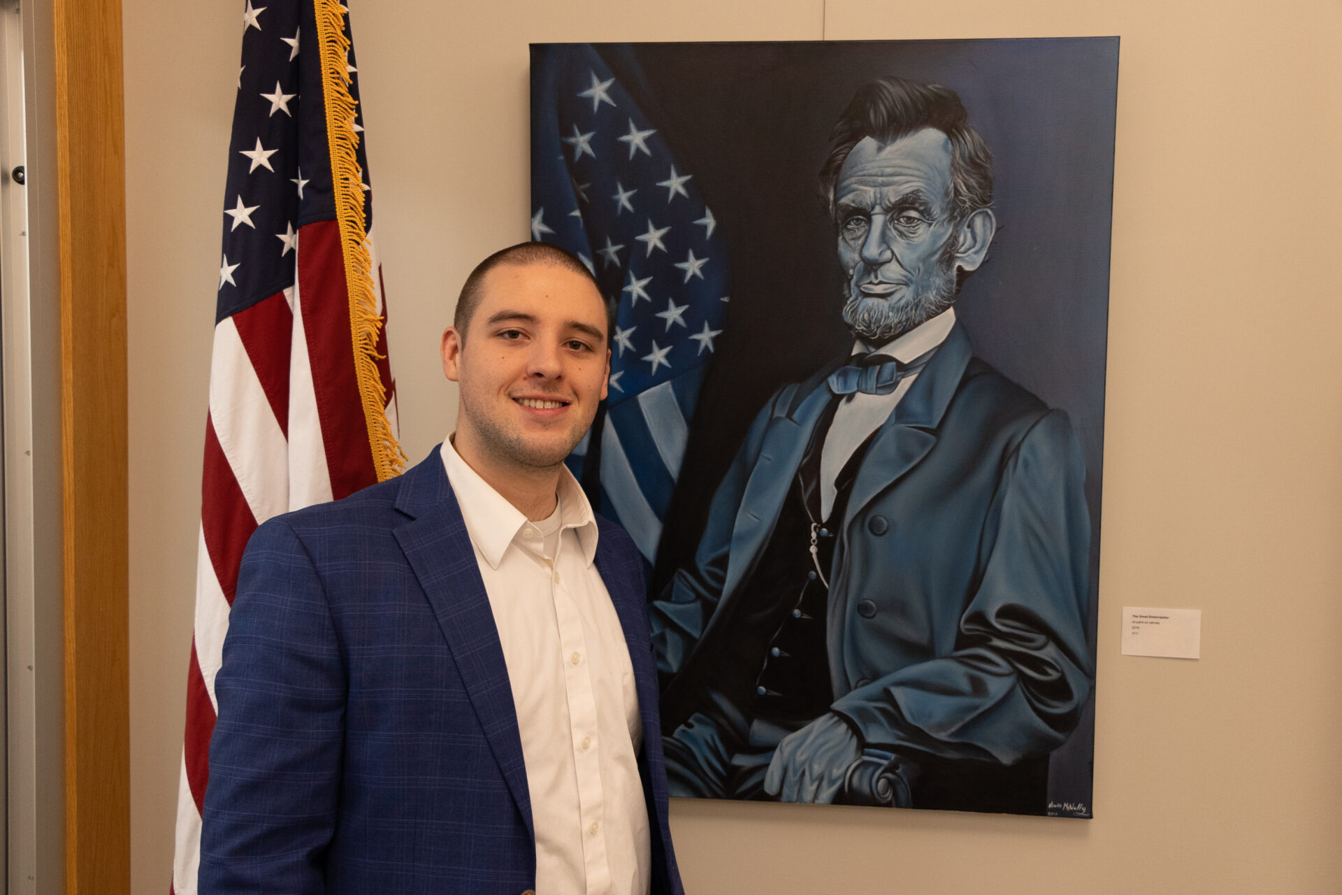 Artist Nevin McNally Stands next to his painting