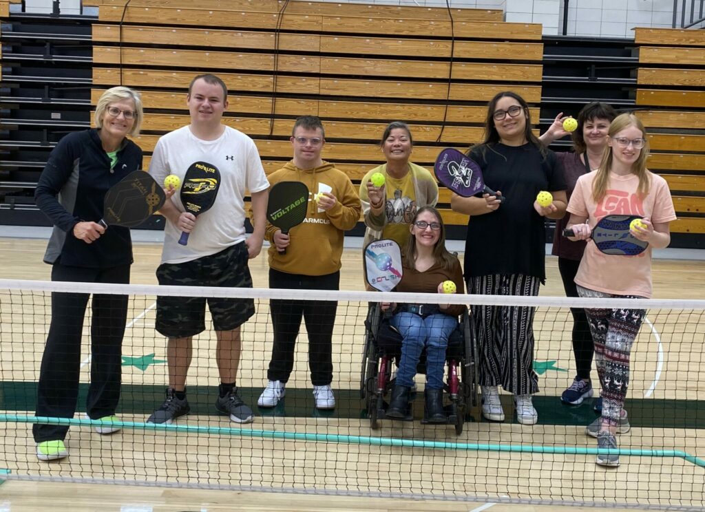 College for Life students posing with pickleball coach